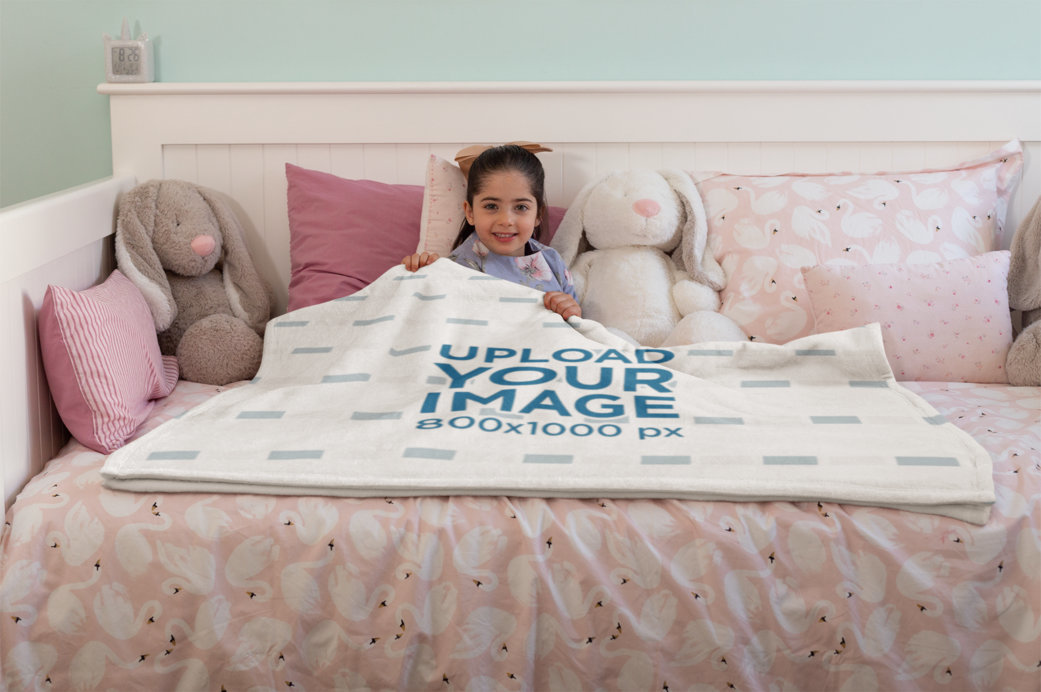 Mockup of a Happy Little Girl Lying Under a Throw Blanket on her Bed