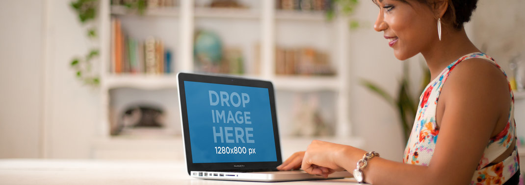 Mockup of a Woman in a Flower Garment Using a Macbook at Home 