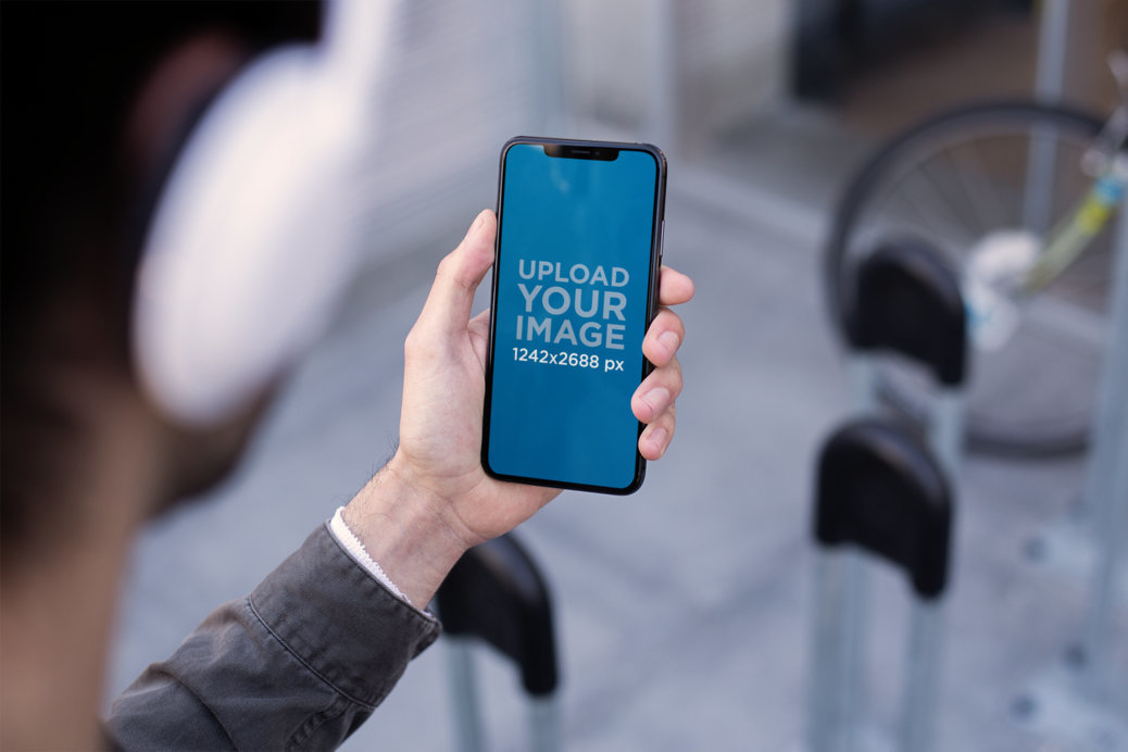 iPhone 11 Pro Max Mockup of a Man Listening to a Podcast Next to a Bike Rack