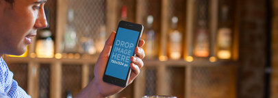 iPhone Mockup Featuring a Man Using an iPhone at a Bar