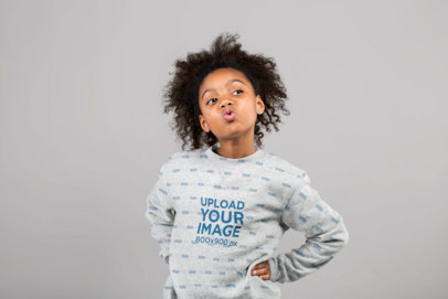 Mockup of a Little Girl Blowing a Kiss Wearing a Heathered Crewneck Sweatshirt  at a Studio