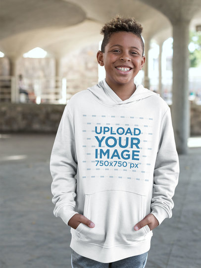 Pullover Hoodie Mockup Featuring a Kid Smiling in Urban Outdoors