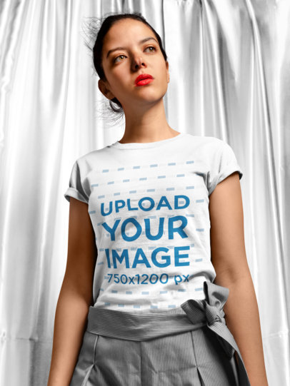 T-Shirt Mockup of a Woman Standing in Front of a Curtain