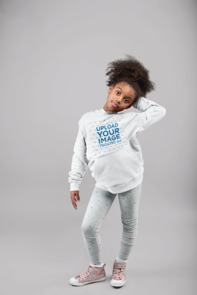 Mockup of a Little Girl With Kinky Hair Ponytail Posing with a Pullover Hoodie at a Studio