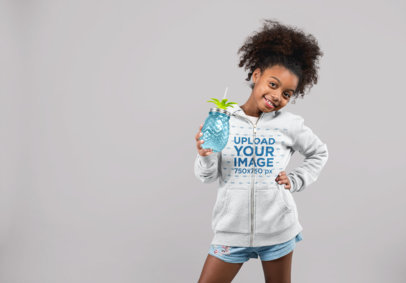 Mockup of a Little Girl Wearing Full Zip Hoodie While Holding a Jar