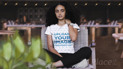 Parallax Video of a Girl with Kinky Hair Sitting in a Relaxing Area Wearing a Crew Neck T-Shirt 26328