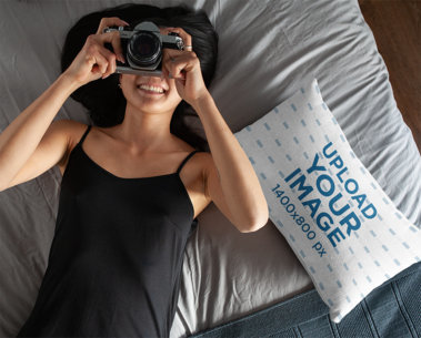 Pillow Mockup Featuring a Woman Taking a Photo with a Retro Camera