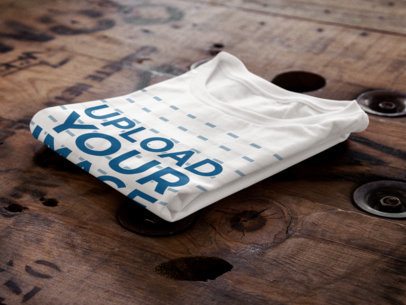 T-Shirt Mockup of a Folded T-Shirt Over a Wooden Surface