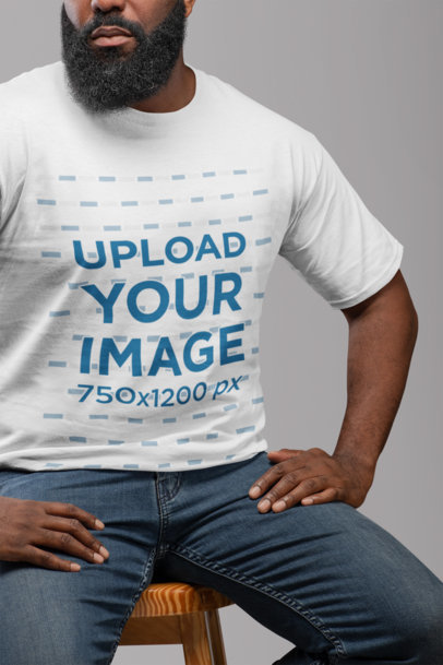 T-Shirt Mockup Featuring a Man with a Beard Sitting on a Chair