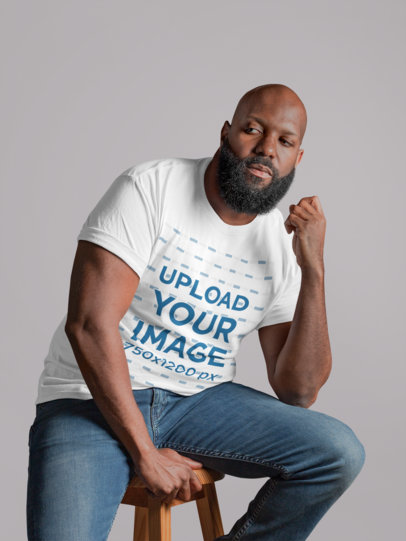 T-Shirt Mockup of a Thoughtful Man Sitting on a Chair 