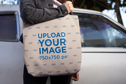 Mockup of a Woman Carrying a Tote Bag in Front of an Abandoned Car