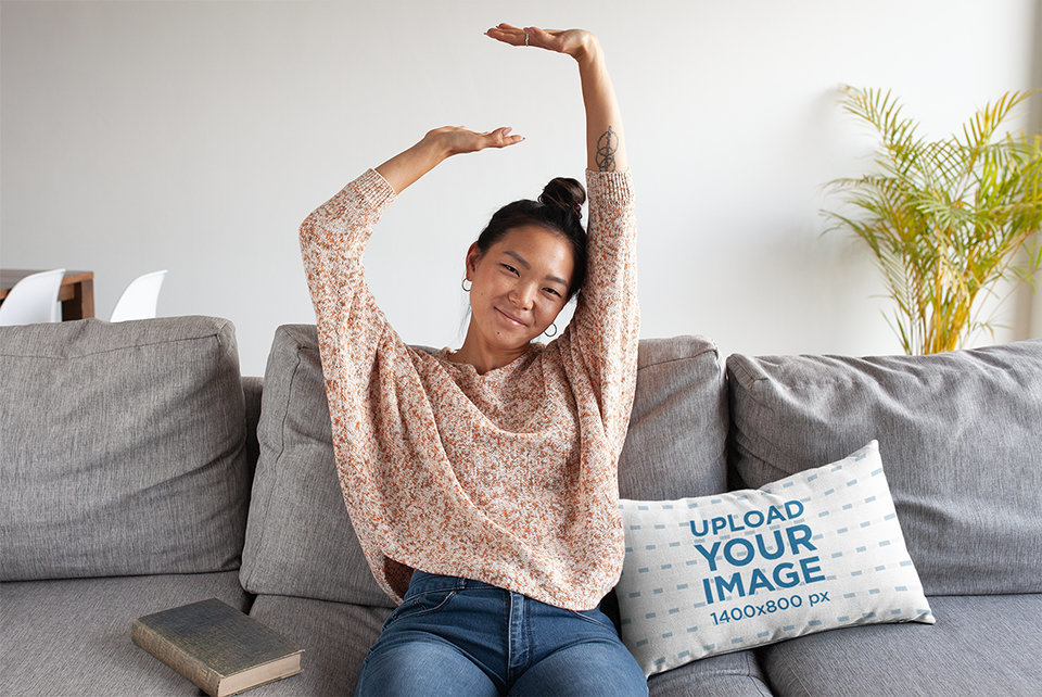 Pillow Mockup Featuring a Woman Stretching Her Arms on a Sofa