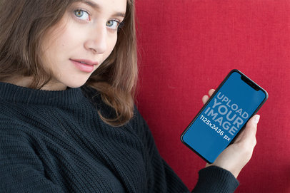 iPhone XS Mockup of a Girl Against a Red Linen Fabric 25364