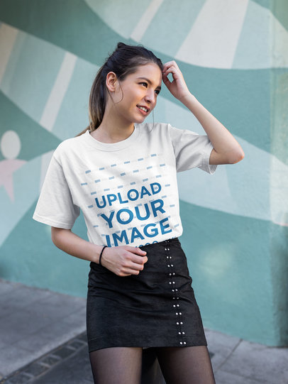 Tee Mockup of a Fashionable Woman Standing in Front of a Graffiti Wall