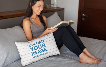Pillow Mockup of a Smiling Woman Reading in Bed