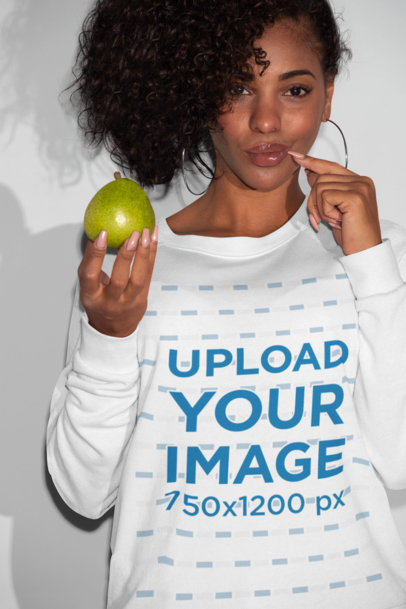 Sweatshirt Mockup of a Woman Posing with a Fruit in Her Hand 