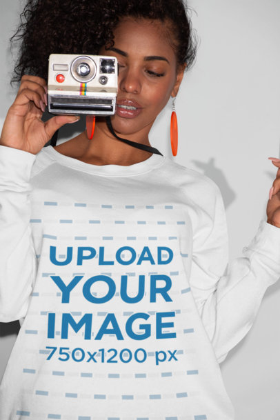 Crewneck Sweatshirt Mockup of a Woman Holding a Retro Instant Camera