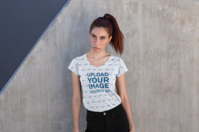 V-Neck Sublimated Tee Mockup of a Red Haired Woman Posing in Front of a Concrete Wall
