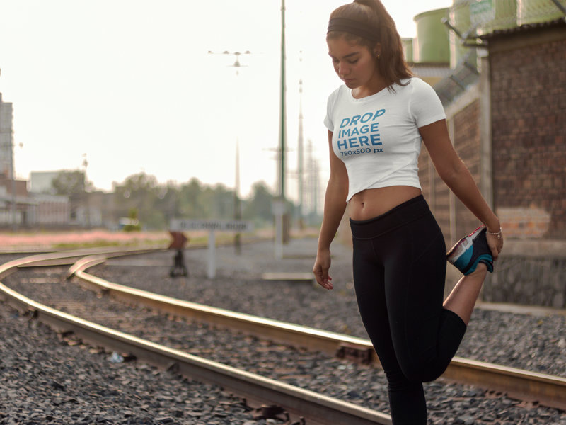 T-Shirt Mockup of a Woman Wearing Activewear Outdoors