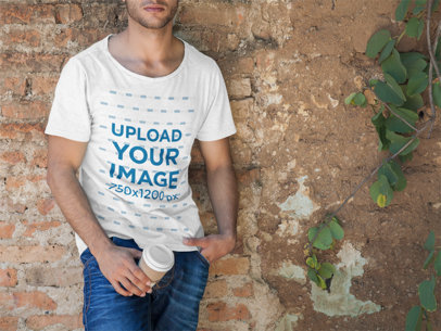 T-Shirt Mockup of a Man Leaning Against a Brick Wall