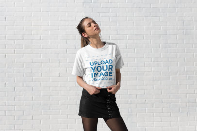 Tee Mockup of a Stylish Woman Standing Under the Sun with Her Eyes Closed
