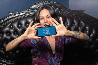 Mockup of an Excited Woman Showing an iPhone XS in Landscape Position 25376
