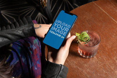 iPhone XS Mockup Featuring a Woman Having a Cocktail 25379