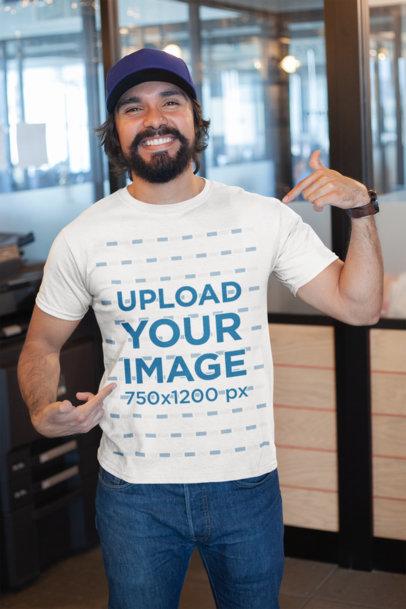Mockup of a Happy Customer Pointing at His T-Shirt Inside a Modern Office