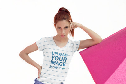 Sublimated V-Neck Tee Mockup of a Woman with Freckles Leaning over a Pink Structure