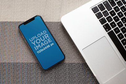 Mockup of an iPhone XS Lying Next to a Laptop 25393