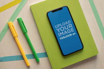 iPhone XS Mockup with a Desk Setup Featuring Writing Supplies 25488