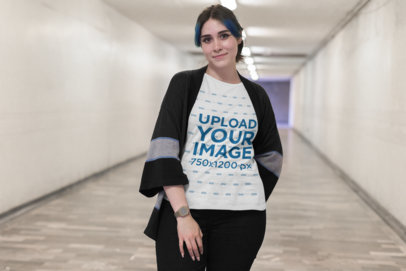 Mockup of a Woman Wearing a Plus Size Tee in a Long Urban Hallway