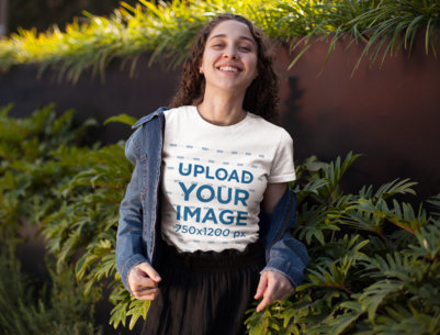 T-Shirt Mockup of a Smiling Curly-Haired Girl Standing by Some Bushes 25799