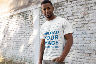 T-Shirt Mockup of a Fit Man in Front of an Old Block Wall 25925a