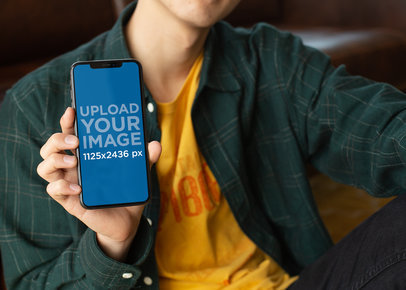 Mockup of a Slim Man Holding an iPhone X 25546
