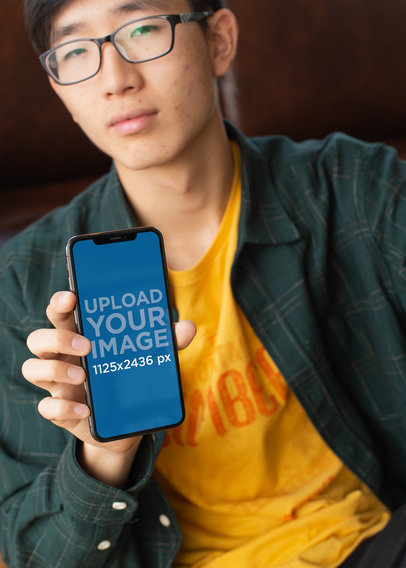 Mockup of a Geeky Looking Man Showing Off His iPhone X 25545