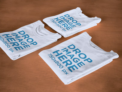 Folded T-Shirts Mockup Lying on Top of a Wooden Surface6482a