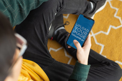 iPhone 11 Pro Mockup Featuring a Man Sitting on a Rug