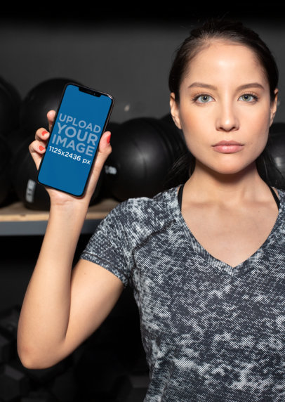 Mockup of a Woman Showing Her iPhone 11 Pro at the Gym