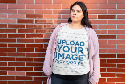 Plus Size Tee Mockup of a Woman with a Pink Coat Posing by a Brick Wall