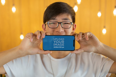 Mockup of a Happy Man with Glasses Showing His iPhone 11 Pro