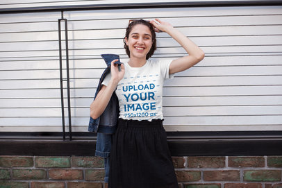 T-Shirt Mockup Featuring a Smiling Woman Posing on an Urban Scenario