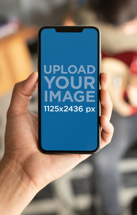 Mockup of an iPhone 11 Pro with a Guy Playing Guitar in the Back 