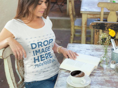 T-Shirt Mockup of a Woman at a Cafe Reading a Book