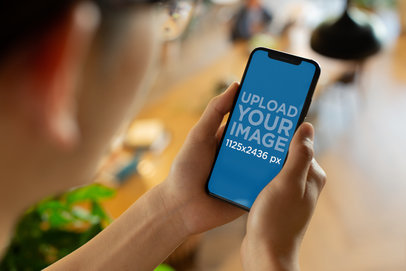 Mockup of the Over Shoulder Look of a Young Man's iPhone 11 Pro