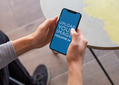 Mockup of an iPhone 11 Pro Held by a Man Outside