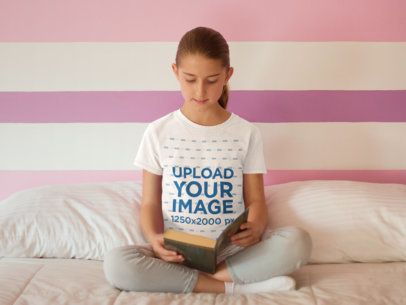 T-Shirt Mockup Featuring a Girl Reading a Book in Bed 