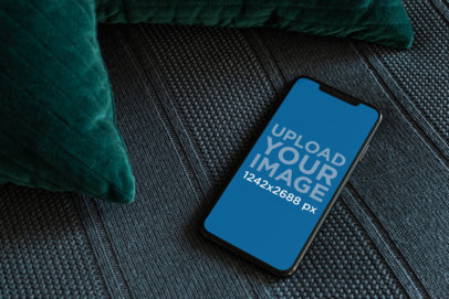 iPhone XS Max Mockup Lying over a Dark Cushioned Surface 25888