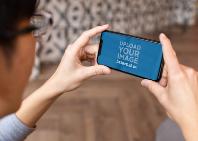 Digital Mockup Featuring a Man Watching His iPhone 11 Pro