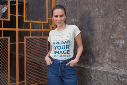 Tee Mockup of a Woman Posing by a Modern Art Deco Door